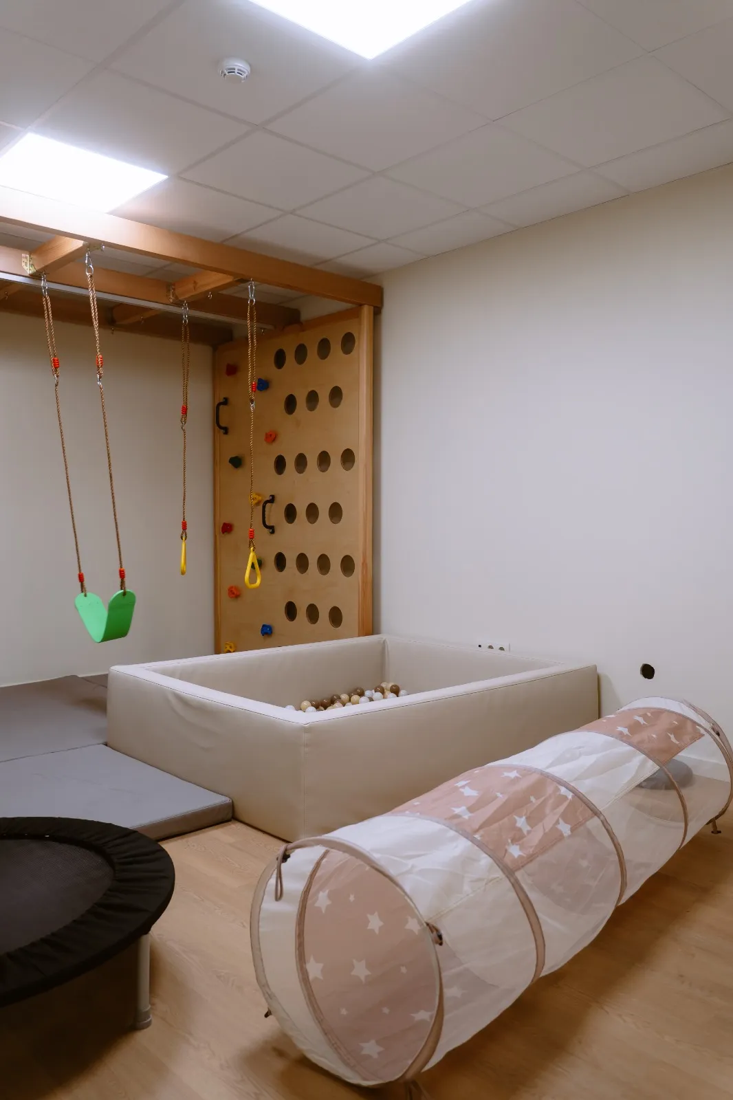 Sala para crianças com baloiços, piscina de bolas e túnel de brincar